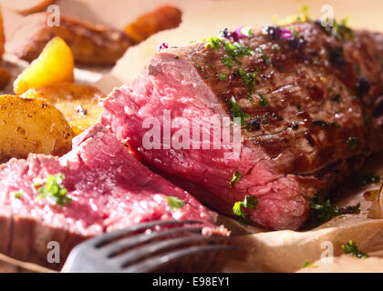 Teil des saftigen selten Roastbeef zum Abendessen mit einer Nahaufnahme der Textur des gesunden mageres rotes Fleisch geschnitzt Stockfoto