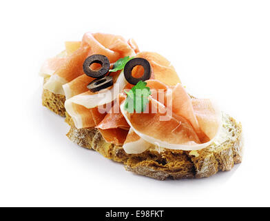 Gournet in dünne Scheiben geschnitten würzigen ausgehärteten deutscher Schinken Schinken auf Brot mit in Scheiben geschnittenen schwarzen Oliven und Kräutern für eine köstliche traditionelle Snacks Stockfoto