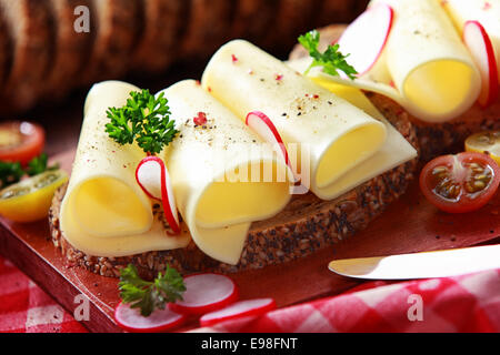 Leckere Gouda-Käse-Sandwich auf Vollkornbrot, garniert mit Scheibe Radieschen und Petersilie mittags ein gesundes Land, Nahaufnahme Stockfoto