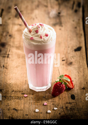 Beeren-Smoothies oder Milchshakes in ein hohes Glas, hergestellt aus einer Mischung von frischen Erdbeeren und Himbeeren mit frozen Joghurt oder Eis für ein Sommer-Erfrischungsgetränk Stockfoto