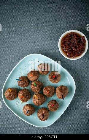 Draufsicht auf einen Teller gewürzte Frikadellen und herzhaften würzigen Tomaten und Chili-Pfeffer-Dip für Vorspeisen, Draufsicht auf Stockfoto