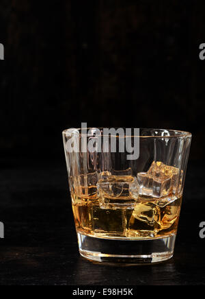 Eisgekühltes Bourbon oder Whisky in einem Tumbler Glas auf einem dunklen Hintergrund mit vertikalen Exemplar Stockfoto