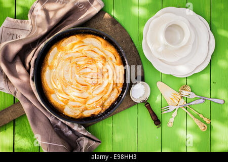 Kaffee-Zeit im Garten mit frischen Apfelkuchen mit einer Draufsicht auf eine leere Tasse und Kuchen Teller neben einer goldenen Torte in Stockfoto