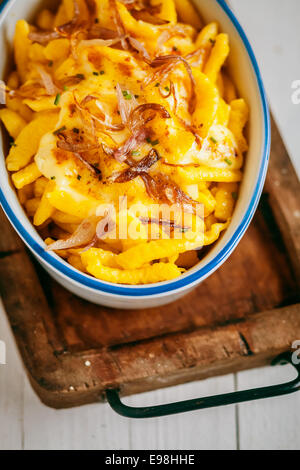 Deutsche oder bayerische Küche mit Spätzle oder traditionelle Ei sich gemacht durch strömenden Teig durch ein Sieb in kochendes Wasser in einer Kasserolle mit pikanter sauce Stockfoto