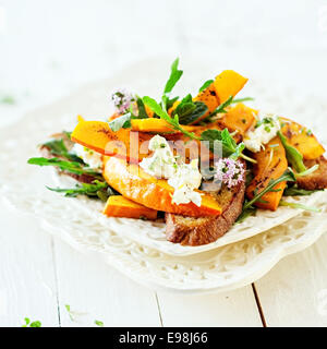 Gourmet frische moderne Sommersalat mit Kürbis gebraten serviert am Tisch. Stockfoto