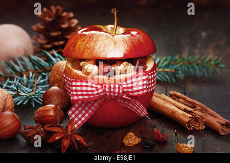 Weihnachtlichen Gewürzen in Red Apple mit Band, Zimt-Sticks, Anis und Muttern auf Seite. Stockfoto