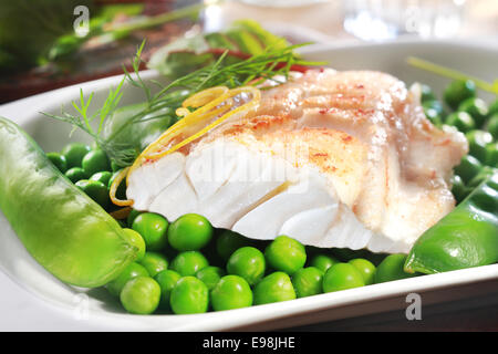 Gesunder Fisch vom Grill Steak mit Erbsen, Kefengemüse und Zitronenschale auf dem Silbertablett serviert als Vorspeise oder Hauptgericht Stockfoto