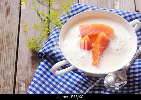 Gourmet-frischer Lachs Chowder Suppe mit Stücken von rohem Lachsfilet in einer schaumig cremige Suppe betrachtet hohen Winkel auf einer rustikalen blauweißen aufgegebenes Serviette mit Fenchel Stockfoto