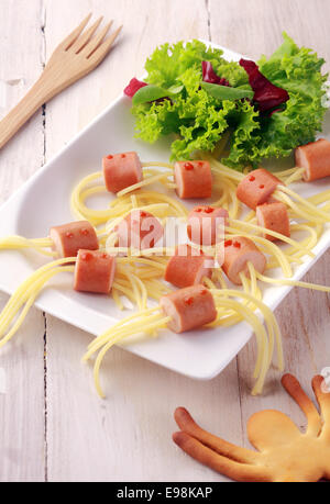 Wiener und Nudel-Spider-Snacks auf weißen Teller mit garnieren Schuss von oben Stockfoto