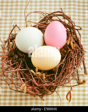 Drei gekochte gefärbte Ostereier in einem Nest für Frohe Ostern Stockfoto