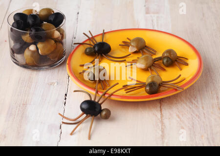 Hausgemachte kreative Halloween Spinne Snacks oder Vorspeisen gebildet von grünen und schwarzen Oliven mit italienischen Spaghetti Nudeln Beinen in Stockfoto
