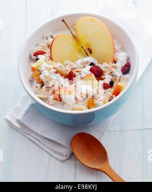 Köstliches hausgemachtes Müsli mit Obst, einschließlich frisch halbiert und gewürfelten Apfel und getrockneten Aprikosen und Rosinen und Nüssen serviert einer Stockfoto