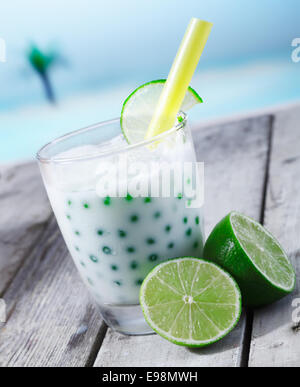 Frische Diffusorleitrades Perlen Tee mit Limette Sirup stand vor dem Strand auf einer Holzplatte Stockfoto