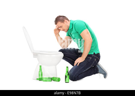 Betrunkener Mann beugte sich über eine Toilette, die isoliert auf weißem Hintergrund Stockfoto
