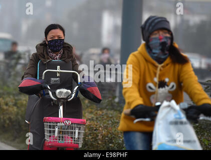 Taiyuan, China Shanxi Provinz. 22. Oktober 2014. Menschen tragende Masken fahren Sie an einem dunstigen Tag in Taiyuan, Hauptstadt der Provinz Nord-China Shanxi, 22. Oktober 2014. Die anhaltende Smog hat die Stadt seit Okt. 19 gehüllt. Bildnachweis: Yan Yan/Xinhua/Alamy Live-Nachrichten Stockfoto