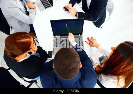 Geschäftsleute, die auf einer Sitzung am Tisch sitzen Stockfoto