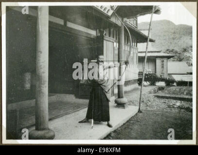 Dieses Vintage-Foto aus dem Jahr 1935 zeigt einen japanischen Bogenschützen in Unzen, Japan, mit einem traditionellen Pfeil und Bogen. Das Bild fängt einen Moment des kulturellen Erbes und der historischen Nutzung des Bogenschießens in Japan ein. Stockfoto