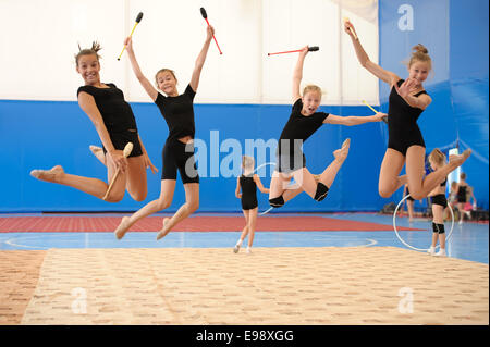 Mädchen mit indischen Clubs im Hochsprung Stockfoto