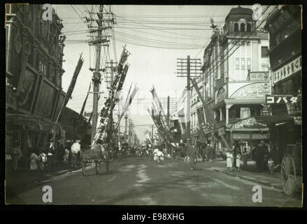 Ein Foto der Theatre Street in Yokohama, Japan, zeigt die lebendige Straßenszene und Architektur dieser historischen Gegend. Das Bild zeigt die geschäftige Atmosphäre der Straße im frühen 20. Jahrhundert. Stockfoto