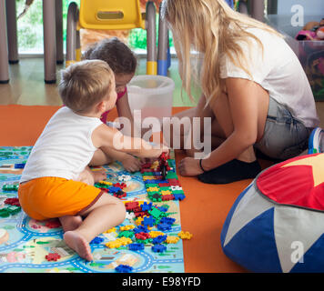 Puzzle mit Tutor im Kindergarten zu tun Stockfoto