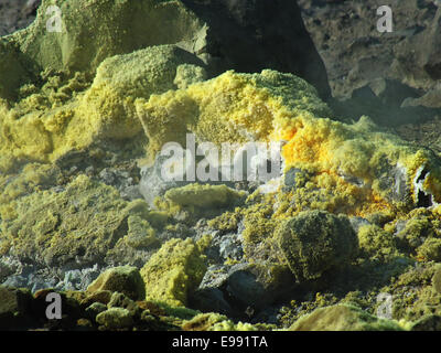 Vulkan: heiße Wolken und giftige Schwefel Dämpfe hoch. Bizarre Steinblöcke sind gelb gefärbt. Aus tiefen Felsspalten Nässen rote kochenden Schwefel. -Juni 2014 Stockfoto