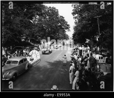 Dieses Foto zeigt eine Parade, die die lebhafte Atmosphäre und die Teilnehmer in ihrer lebendigen Kleidung festmacht. Die Veranstaltung zeigt eine traditionelle Feier, bei der Einzelpersonen durch die Straßen marschieren und einen festlichen Moment in der Geschichte hervorheben. Stockfoto