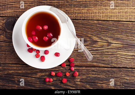 Draufsicht auf eine Tasse Tee mit Walderdbeeren Stockfoto