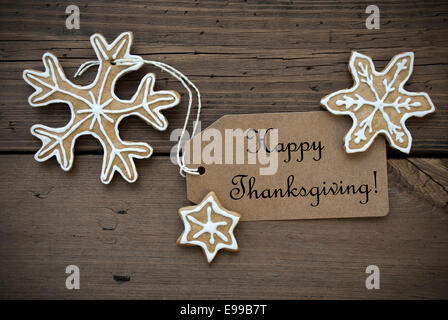Happy Thanksgiving geschrieben auf einem braunen Etikett mit Ingwer-Brot-Plätzchen mit weißen Verzierungen, Thanksgiving-Hintergrund Stockfoto