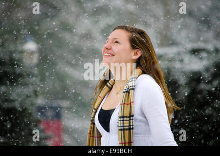 Leise rieselt der Schnee: eine junge Frau ihren Kopf erhebt gegen eine schöne Schnee-Dusche. Stockfoto