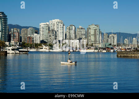 Mann sitzt allein in einem kleinen Segelboot, False Creek, Vancouver, Britisch-Kolumbien, Kanada Stockfoto