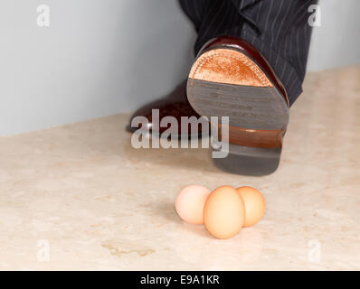 Mannes Schuh Stempeln auf drei Eiern Stockfoto