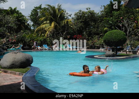 Matahari Bungalow Hotel-Pool in Kuta Legian Street. Bali. Ein Vater badet mit ihrer Tochter. Swimmingpool des Hotels. Kuta ist eine Küste Stockfoto