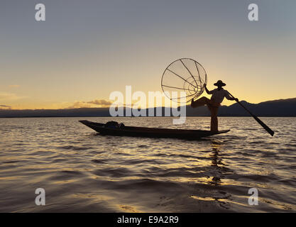 Silhouette eines burmesischen Fischers auf See Inly in der untergehenden Sonne. Stockfoto