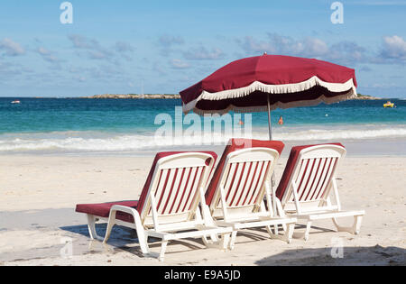 Drei am Strand Liegestühle und Sonnenschirm auf sand Stockfoto