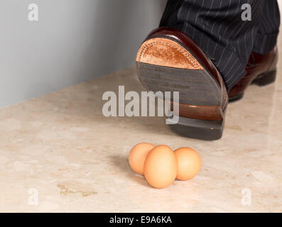 Mannes Schuh Stempeln auf drei Eiern Stockfoto