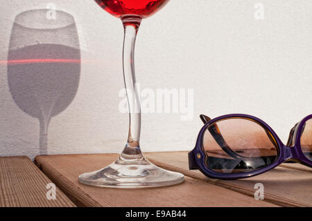 Wein und Sonnenbrille auf Deck Stockfoto