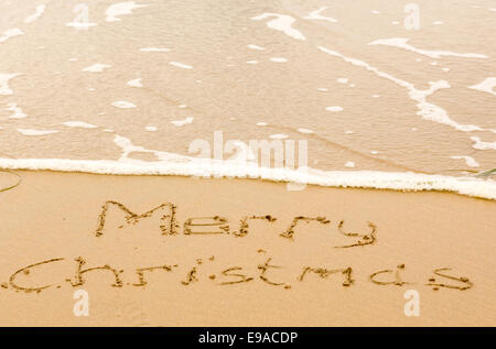 Frohe Weihnachten, geschrieben im Sand am Strand Stockfoto