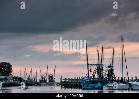 Krabbenkutter angedockt entlang Shem Creek bei Sonnenuntergang in Mount Pleasant, South Carolina. Stockfoto