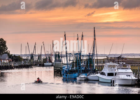 Krabbenkutter angedockt entlang Shem Creek bei Sonnenuntergang in Mount Pleasant, South Carolina. Stockfoto