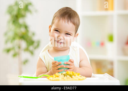 lächelndes Kind junge Essen drinnen Stockfoto