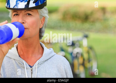 Frau Trinkwasser im park Stockfoto