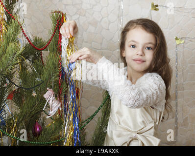 Schönes Mädchen schmückt den Weihnachtsbaum. Stockfoto