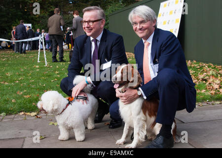 London, 23. Oktober 2014. Organisiert von den Dogs Trust und der Kennel Club, versammeln sich Politiker und ihre Pooches außerhalb des Parlaments für die 22. Westminster Dog of the Year Wettbewerb, zur Sensibilisierung der Hund wohl im Vereinigten Königreich, wo die Hunde Vertrauen mehr als 16.000 streunenden und verlassene Hunde jährlich kümmert sich um. Bild: Michael Gove und Andrew Mitchel posieren mit ihren Hunden Snowy (links) und Scarlet. Bildnachweis: Paul Davey/Alamy Live-Nachrichten Stockfoto