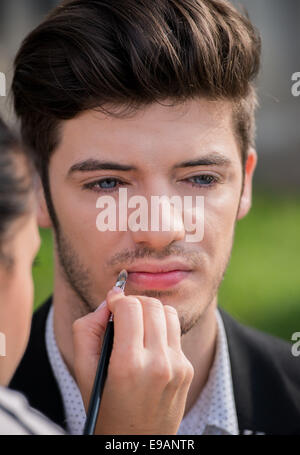 Attraktive junge Mann während einer Make-up-Sitzung Stockfoto