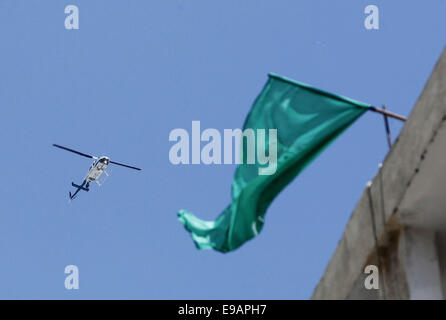 Jerusalem, Palästina. 23. Oktober 2014. Eine israelische Flugzeug fliegt über die Heimat des palästinensischen Mann Abdelrahman Shaludi, der ein Baby getötet und verletzt und sechs andere in Jerusalem, nachdem er sein Fahrzeug in Fußgänger in der Nähe von einer Straßenbahn rammt in der sogenannten israelische Polizei '' Fahrerflucht Terrorangriff '', schaut zu, wie ihre Schwester sein Porträt auf ihre Familie zu Hause im Stadtteil East Jerusalem von Silwan am 23. Oktober hält , 2014. Shaludi starb an seinen Verletzungen, nachdem er erschossen wurde und von der Polizei verletzt, als er versuchte, die Szene zu fliehen. Bildnachweis: Bilder Muammar Awad/APA/ZUMA Draht/Alamy Live News Stockfoto