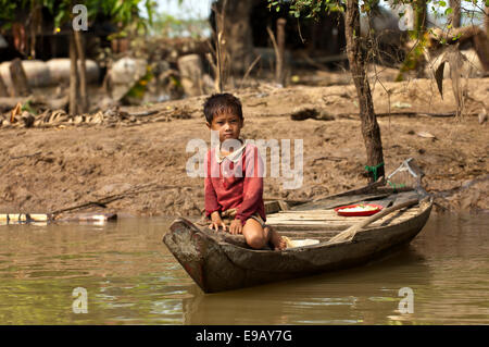 Junge sitzt in einem traditionellen Boot am Fluss Sangker in Battambang, Provinz Battambang, Kambodscha Stockfoto