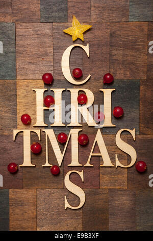 Holzbuchstaben geprägt Baum bilden das Wort "Weihnachten" mit Johannisbeeren Stockfoto