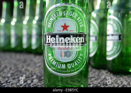Eine Reihe von Heineken Flaschen mit einem auf der Seite auf Beton Stockfoto