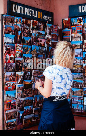 junge weibliche Touristen betrachten Postkarten zum Verkauf in Marrakesch, Marokko Stockfoto