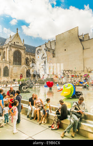 Touristen, die eine Pause bei der Stravinsky-Brunnen in der Nähe der Mitte Georges Pompidou, in der Hintergrund frohe Kirche St. Stockfoto